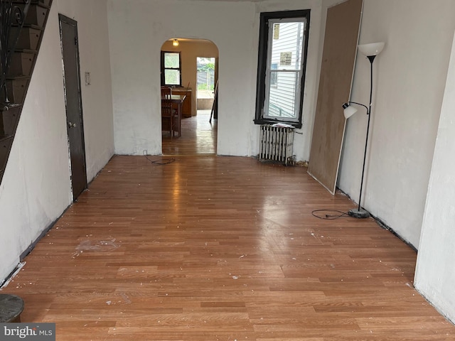 1924 Castor Ave, Philadelphia, PA 19134 - unfurnished room featuring radiator heating unit, arched walkways, and light wood-type flooring