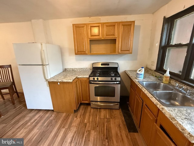 1924 Castor Ave, Philadelphia, PA 19134 - kitchen with freestanding refrigerator, stainless steel gas range, dark wood-style flooring, light countertops, and brown cabinetry