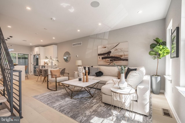 living room with recessed lighting, visible vents, stairway, and baseboards