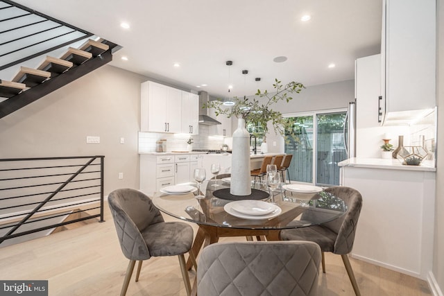 dining area with recessed lighting, light wood-style flooring, and stairs