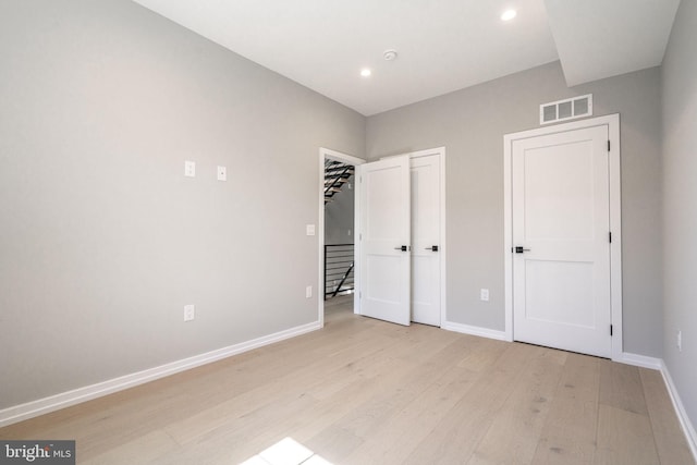 unfurnished bedroom with light wood-style floors, recessed lighting, visible vents, and baseboards