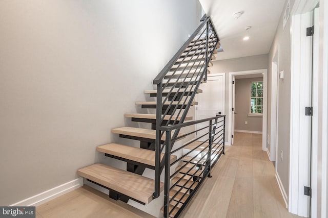 stairway with recessed lighting, baseboards, and wood finished floors