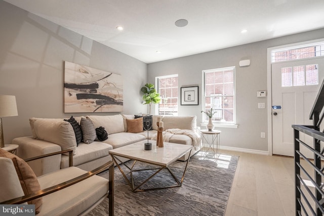 living area featuring recessed lighting, plenty of natural light, baseboards, and wood finished floors