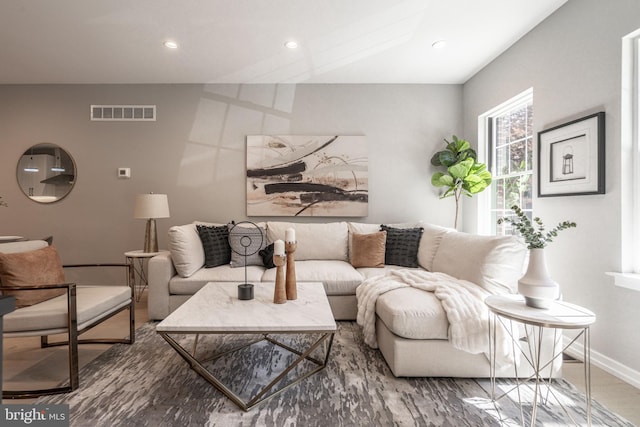 living room with baseboards, visible vents, and recessed lighting