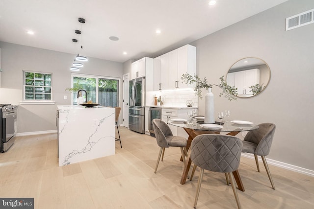 dining space with beverage cooler, recessed lighting, visible vents, and baseboards