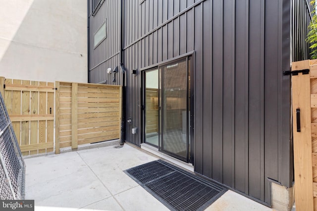 doorway to property featuring board and batten siding and visible vents