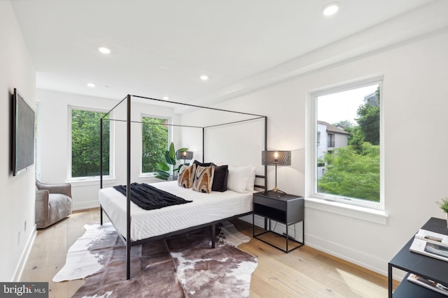 bedroom with baseboards, multiple windows, wood finished floors, and recessed lighting