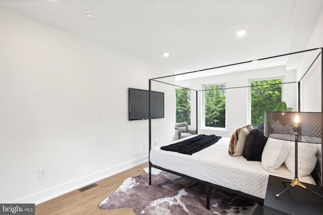 bedroom featuring visible vents, baseboards, wood finished floors, and recessed lighting