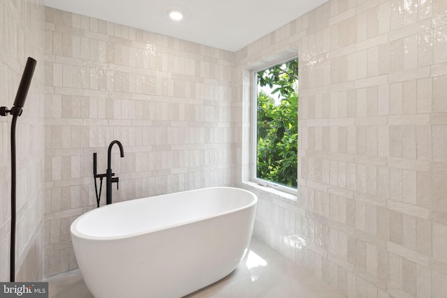 full bathroom featuring a wealth of natural light, a soaking tub, tile walls, and recessed lighting