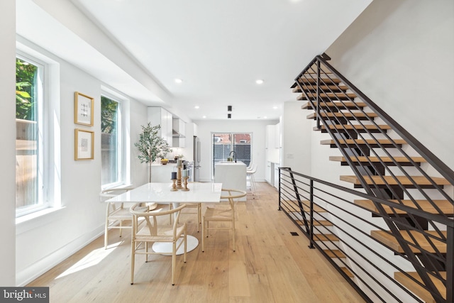 dining area with stairway, light wood-style flooring, baseboards, and recessed lighting