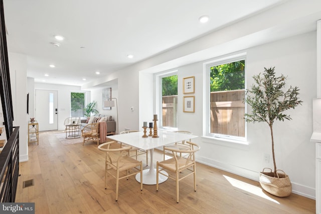 dining room with light wood finished floors, baseboards, visible vents, and recessed lighting