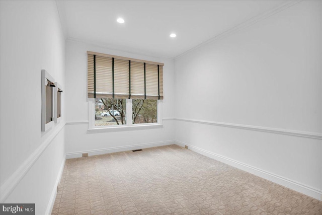 carpeted spare room featuring visible vents, crown molding, and baseboards