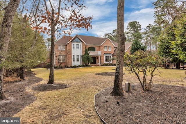 colonial house with a front yard and brick siding