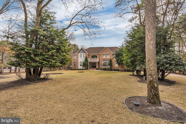 view of front facade with brick siding and a front yard