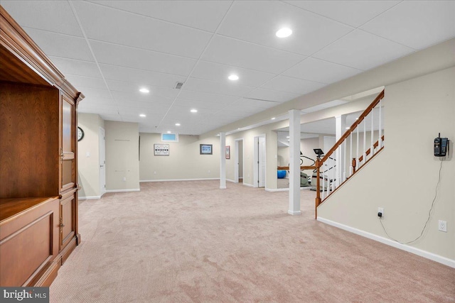 finished below grade area featuring light carpet, recessed lighting, stairs, and baseboards