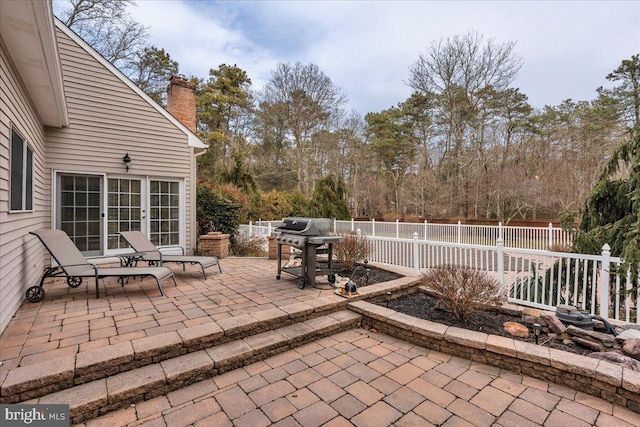 view of patio / terrace with a grill and fence