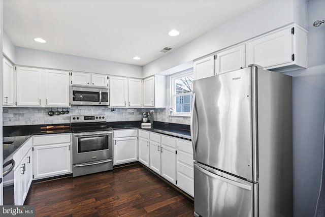 kitchen featuring decorative backsplash, dark countertops, visible vents, and appliances with stainless steel finishes