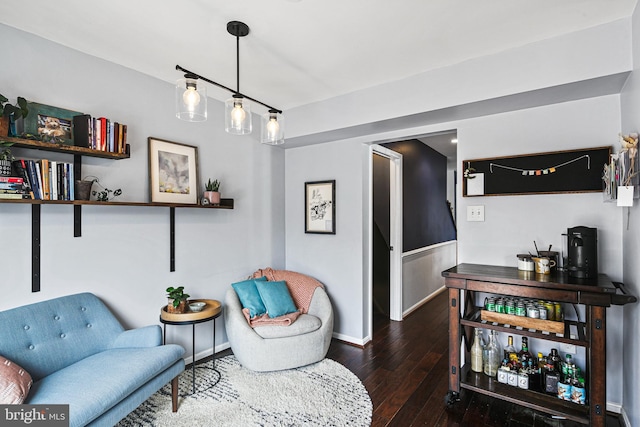 living area featuring baseboards and hardwood / wood-style floors