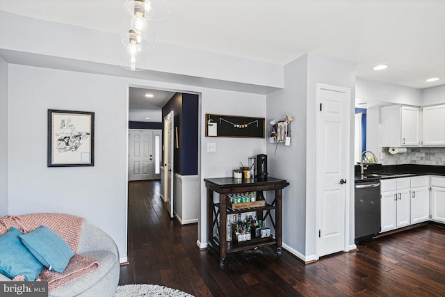 interior space with decorative backsplash, dishwasher, white cabinetry, and dark wood-type flooring