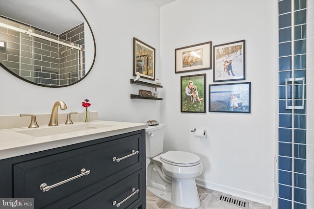 full bath with visible vents, toilet, baseboards, tiled shower, and vanity