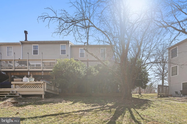 rear view of property featuring a deck and a yard