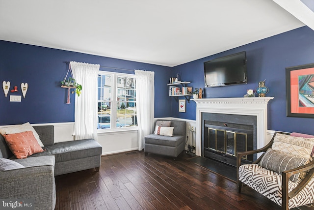 living room with a fireplace with flush hearth and wood-type flooring