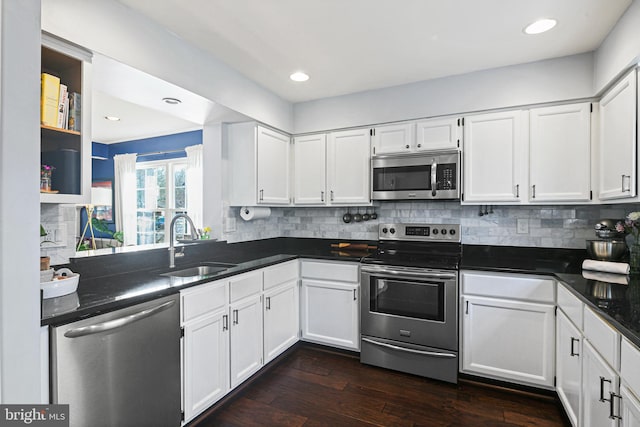 kitchen with white cabinetry, dark wood-style floors, appliances with stainless steel finishes, and a sink