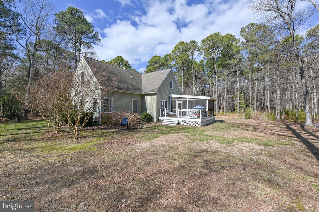 rear view of property with a yard and a sunroom