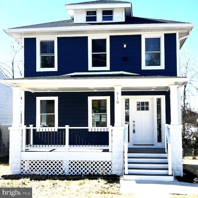 american foursquare style home with a porch