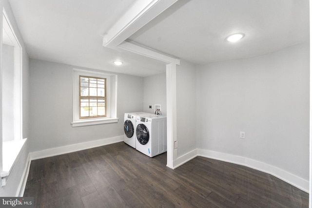 clothes washing area featuring laundry area, washing machine and dryer, baseboards, and dark wood finished floors