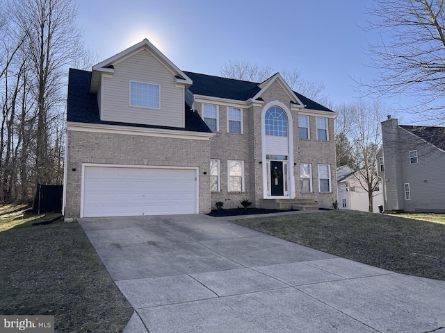 colonial-style house featuring driveway, roof with shingles, an attached garage, a front lawn, and brick siding