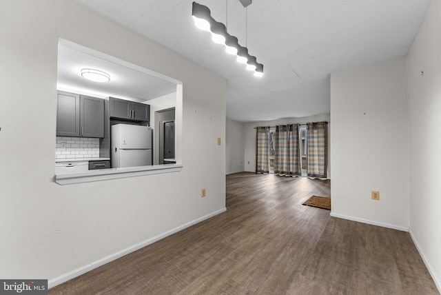 unfurnished living room featuring baseboards and wood finished floors