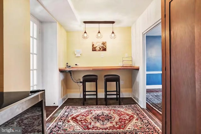 bar with baseboards and hanging light fixtures