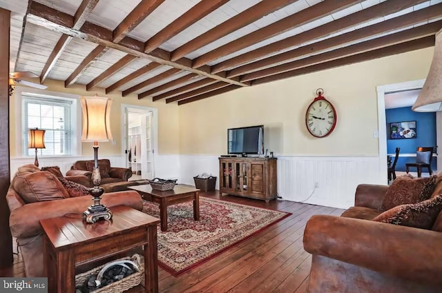 living room featuring lofted ceiling with beams, wainscoting, and hardwood / wood-style flooring