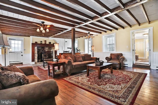 living area with hardwood / wood-style floors, beamed ceiling, a wainscoted wall, and ceiling fan