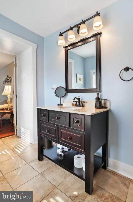 bathroom with tile patterned floors, vanity, and baseboards