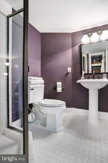 full bath featuring toilet, baseboards, and a stall shower