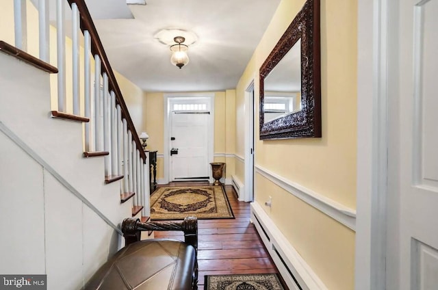 doorway to outside featuring dark wood finished floors, stairs, and baseboard heating