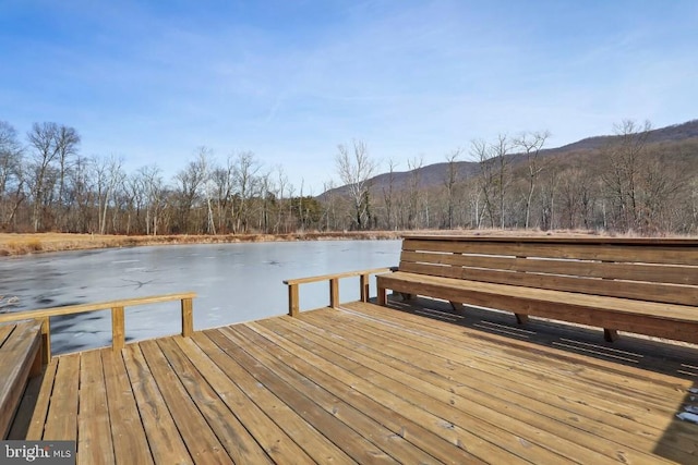 dock area featuring a forest view and a water and mountain view