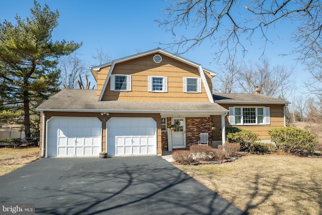 view of front of house featuring brick siding, a chimney, aphalt driveway, and a gambrel roof