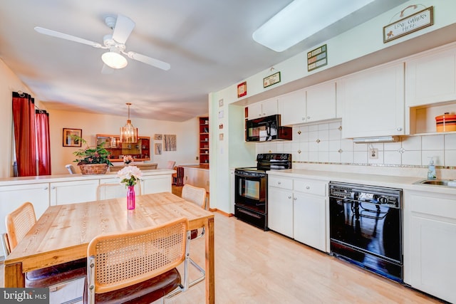 kitchen featuring black appliances, tasteful backsplash, and white cabinetry