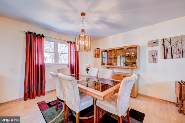 dining space with wood finished floors and baseboards