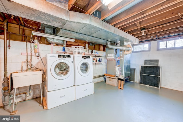 washroom featuring laundry area, a sink, washer and clothes dryer, and heating unit