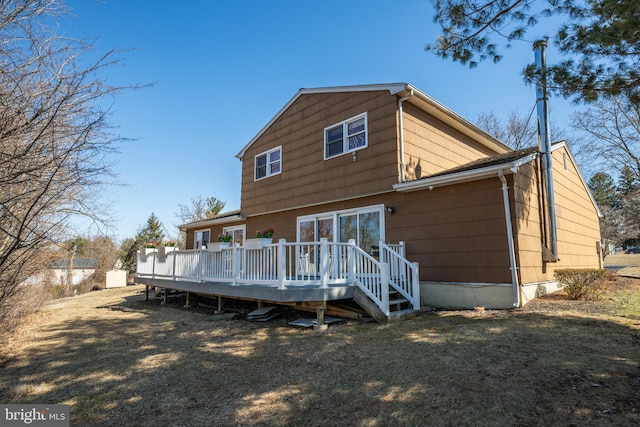 back of property with a deck and a lawn