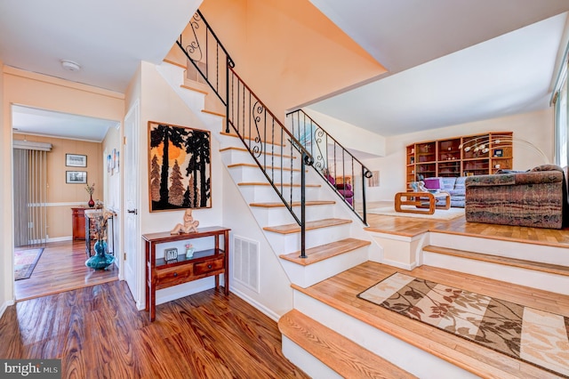 stairway featuring visible vents and wood finished floors