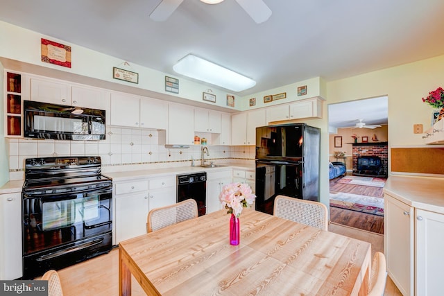 kitchen with ceiling fan, black appliances, light countertops, and white cabinetry