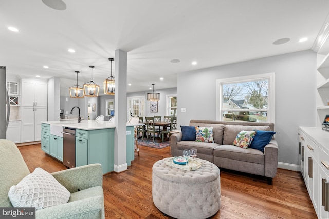 living room with baseboards, wood finished floors, and recessed lighting