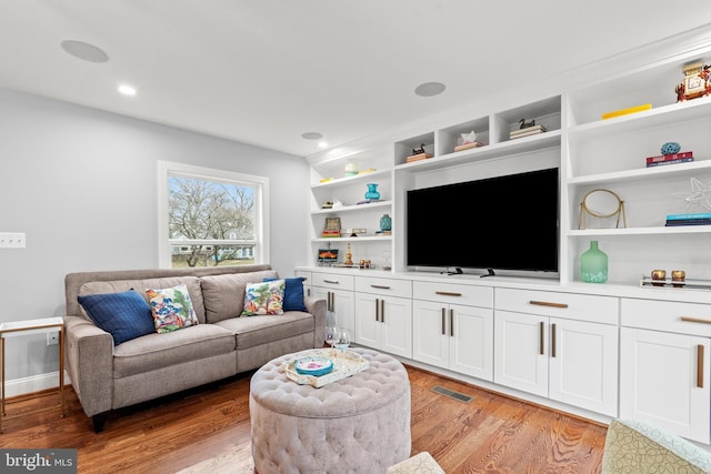 living area featuring light wood finished floors, baseboards, visible vents, and recessed lighting