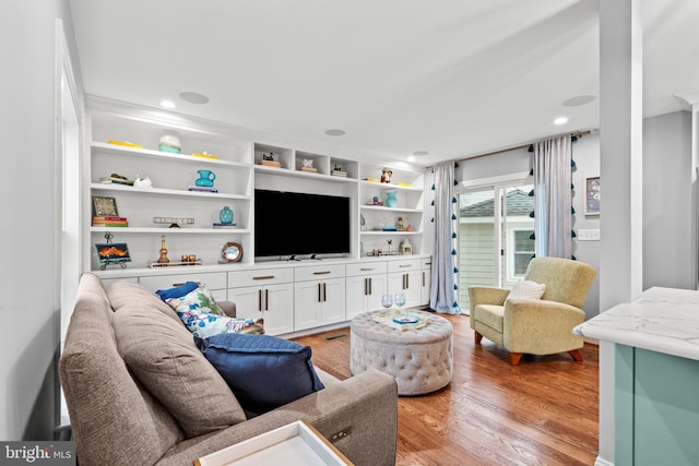 living area featuring built in features, light wood-style flooring, and recessed lighting