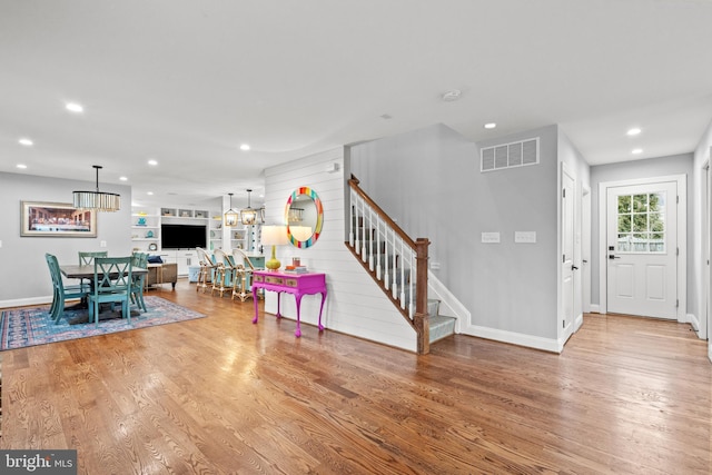 foyer entrance with stairs, wood finished floors, visible vents, and recessed lighting